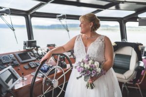 Willamette Star | Wheelhouse | Bride Bride with bouquet with hand on the wheel in the wheelhouse
