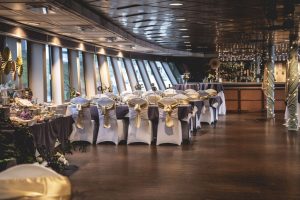 Portland Spirit | Willamette Deck | Chair covers and sashes Inside the Portland Spirit with white chair covers and purple and gold sashes