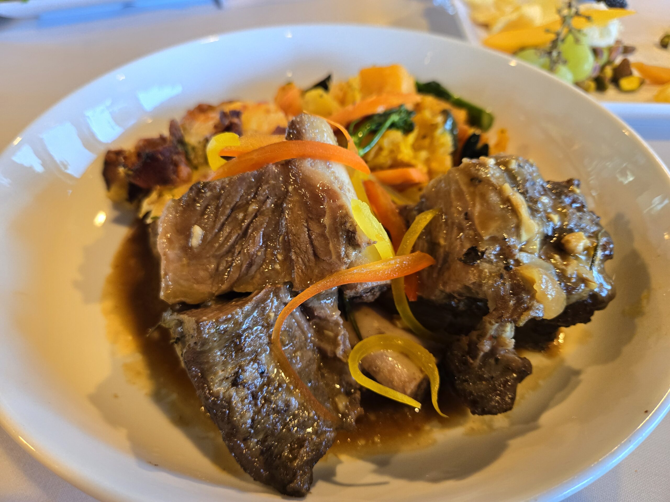 Short ribs served on a plate, glistening with a savory glaze and garnished for a perfect presentation