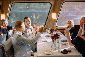 Crystal Dolphin | Willamette Deck | Toast Cheersing on a boat on the Willamette River with flowers on the tables